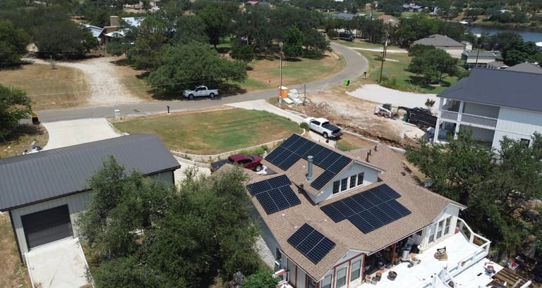 Aerial view of residential home with solar panel roof installation in suburban neighborhood